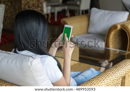 Woman holding mobile smart phone with green screen, Selective focus.