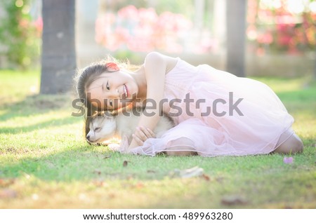 Beautiful asian girl hugging siberian husky puppy in the park,vintage filter
