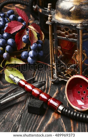 Hookah ,bunch of grapes and stylish Arabic lantern with candle