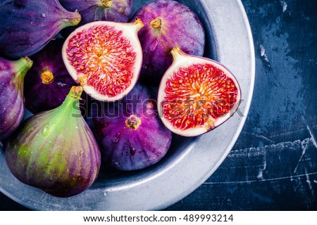 Fresh ripe figs in a bowl closeup on a dark background Royalty-Free Stock Photo #489993214