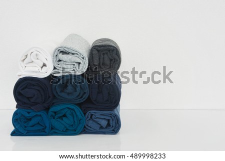stack of t-shirt rolled up on white background, copy space
