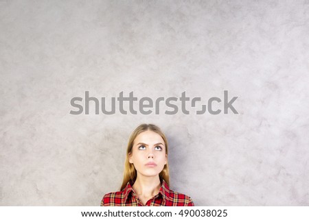 Portrait of pretty young woman on textured concrete wall background with copy space