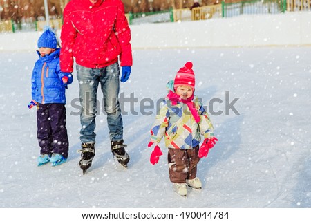 father with two kids skating in winter, family sport