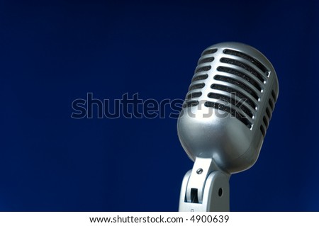 Vintage microphone on blue background with plenty of space for copy