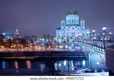 Landmark: the cathedral of Christ the Savior in Moscow by winter night with Patriarch bridge, Moskva river embankment, cloudy sky and urban landscape as a background. Landscape orientation.
