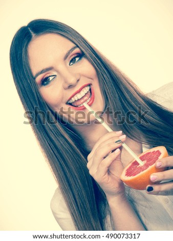 Woman attractive long hair girl eyes makeup holding grapefruit citrus sipping juice from fruit. Healthy diet food. Summer vacation holidays concept. Toned image