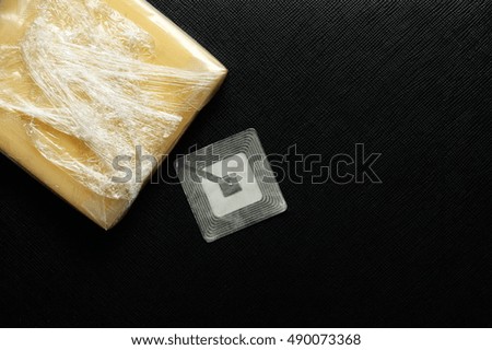 Cheese in thin transparent plastic sealed put on dark back ground scene in the scene appear rfid tag also represent the food and ingredient background concept related idea.