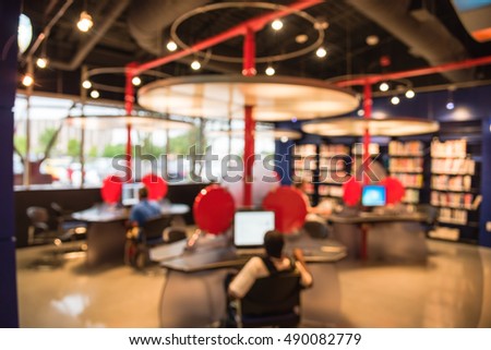 Blurred image of computer station at the public library in Houston, Texas, US. Library interior with unidentified people are searching and reading information. Continued education abstract background