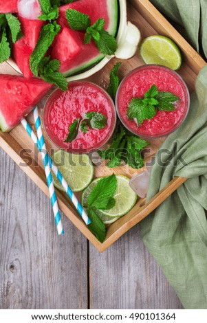 Watermelon slices and drink smoothie on rustic wooden table