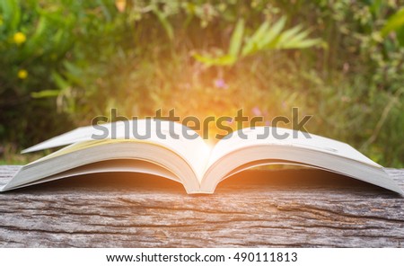 Open book on wood texture on green nature. Vintage effect style picture