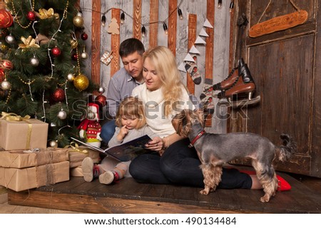 Happy family Christmas. Winter holidays at home.  Family reading a book together.