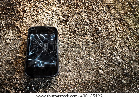damaged smartphone on dirty floor.