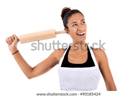 Cook girl goofing around with the rolling pin on isolated white background
