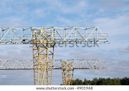 The elevating crane on a background of the light-blue sky