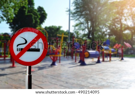 No smoking sign over colorful exercise equipment in public park under sun light - healthy concept