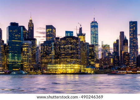 Sunset in New York City with a view of the East River and the  illuminated skyline of Lower Manhattan
