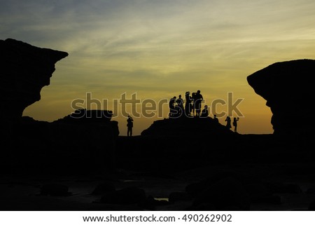 Silhouettes a young people on a beach looking at sunrise at Pura Batu Bolong - Tanah Lot, Bali , Indonesia