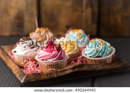 Colorful cupcake dessert on dark wooden background