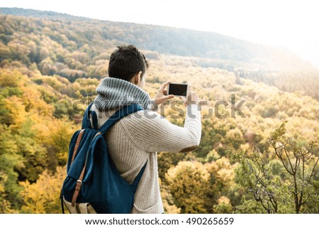 Unrecognizable man with smart phone against colorful autumn fore