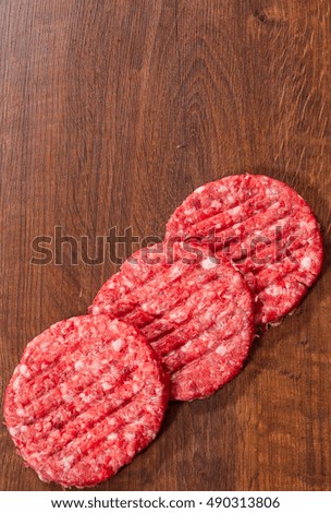 Raw Ground beef meat Burger steak cutlets on wooden table with copy space. top view