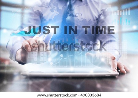 Businessman is using tablet computer, pressing button on touch screen and selecting "Just in time".