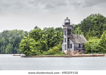 The Grand Island East Channel Lighthouse stands under a cloudy sky on a rainy day in the Munising, Michigan area.