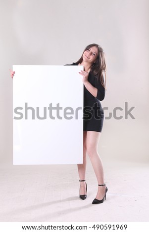 Girl in a black dress with big white piece of paper for lettering