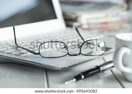 Eyeglasses on laptop and coffee