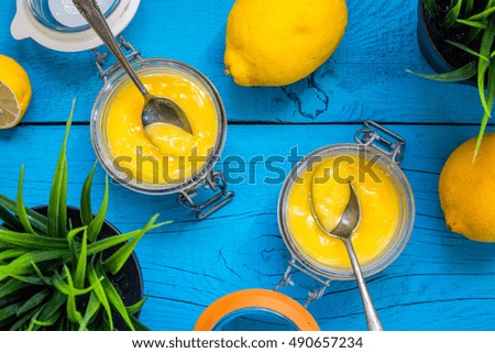 Homemade Yellow Lemon Curd in Jars on Blue Wooden Background, Top View