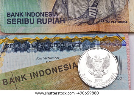 The visa of Indonesia in the passport and the Indonesian rupees, closeup


