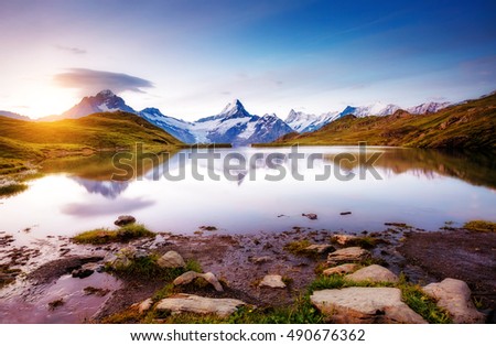 Alpine view of the Mt. Schreckhorn and Wetterhorn. Popular tourist attraction. Dramatic and picturesque scene. Location place Bachalpsee in Swiss alps, Grindelwald valley, Europe. Beauty world.