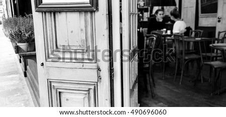 Parisian cafe. Blurred interior with young couple. Romantic Paris concept. Black and white.