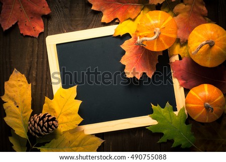 Festive autumn background. Autumn vegetables and leaves around a wooden frame.