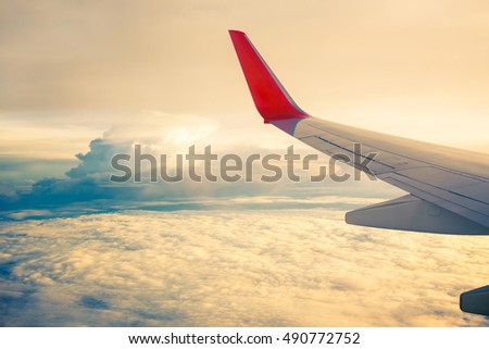 Morning sunrise with Wing of an airplane flying above the ocean. The view from an airplane window. Photo applied to tourism operators. picture for add text message or frame website. Traveling concept