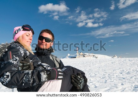 Couple enjoying sunshine on snow