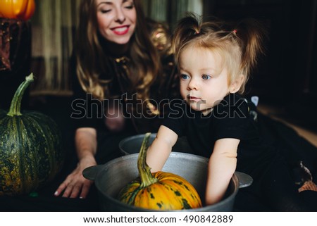 mother and daughter playing together at home on Halloween