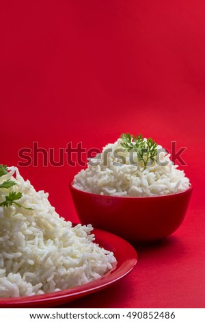 Cooked plain white basmati rice in bowl and plate on red background. 