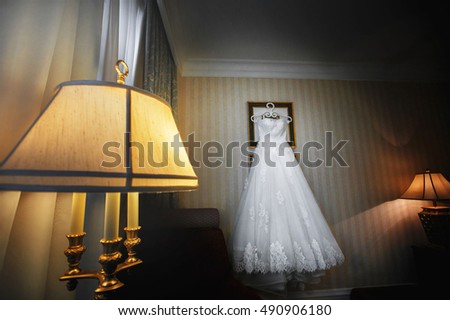 Bridal dress is hanging in the hotel room