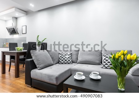 New design home interior with big sofa, wooden dining set and open kitchen