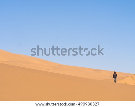 Single man walking on the Namib Desert, Namibia.