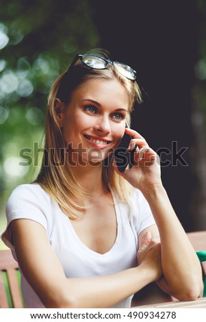 Smiling girl talking on phone in Park