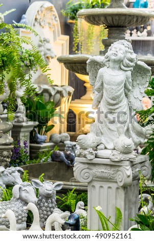 Statue Cupid and waterfall in cozy garden./ Statue of Cupid in cozy garden.
