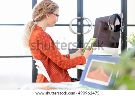 Young woman in office holding a photo frame