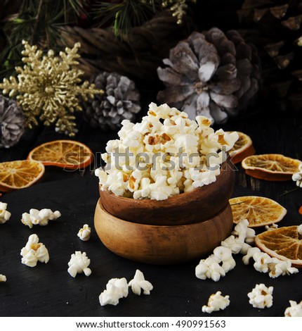 popcorn in a wooden plate on the background of Christmas trees and Christmas decorations, New Year offer, selective focus