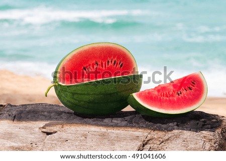 Water melon on the old log with nature background.