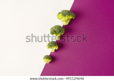 Broccoli on colored violet white background. Diagonal. Seasonal vegetables in modern style design pattern