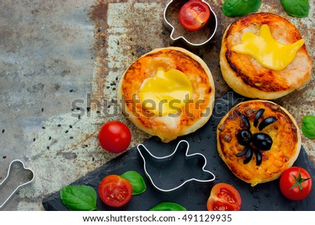 Halloween snack cheese olives spider mini pizza, creative food idea for kids blank space for text