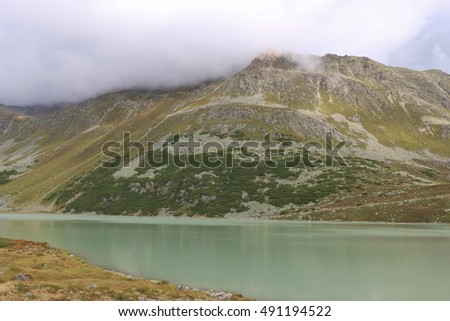 Lake Rifflsee and mountains in the Pitztal in the Oetztal Alps. Tyrol, Austria, Europe.  The lake is located 2200 meters above sea level.