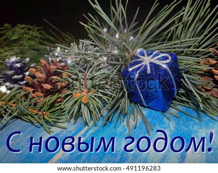 beautiful Christmas decoration with fir tree branches are on blue wooden boards and the inscription "happy new year"