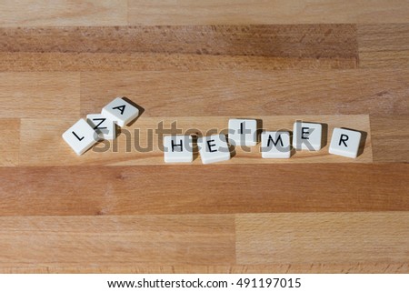 Alzheimer word on a wooden table. First three letters mixed up.